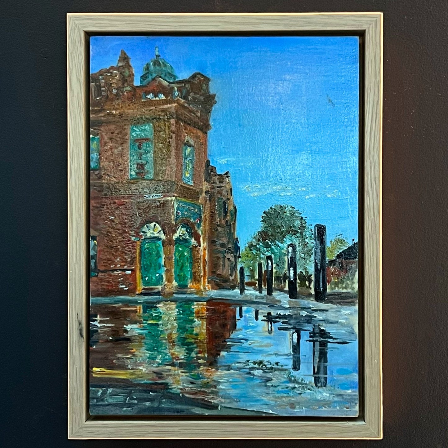 A beautiful painting of the Peveril of the Peak pub in Manchester, capturing its unique green tiled exterior and rain reflections, available at HEADS Art Gallery.
