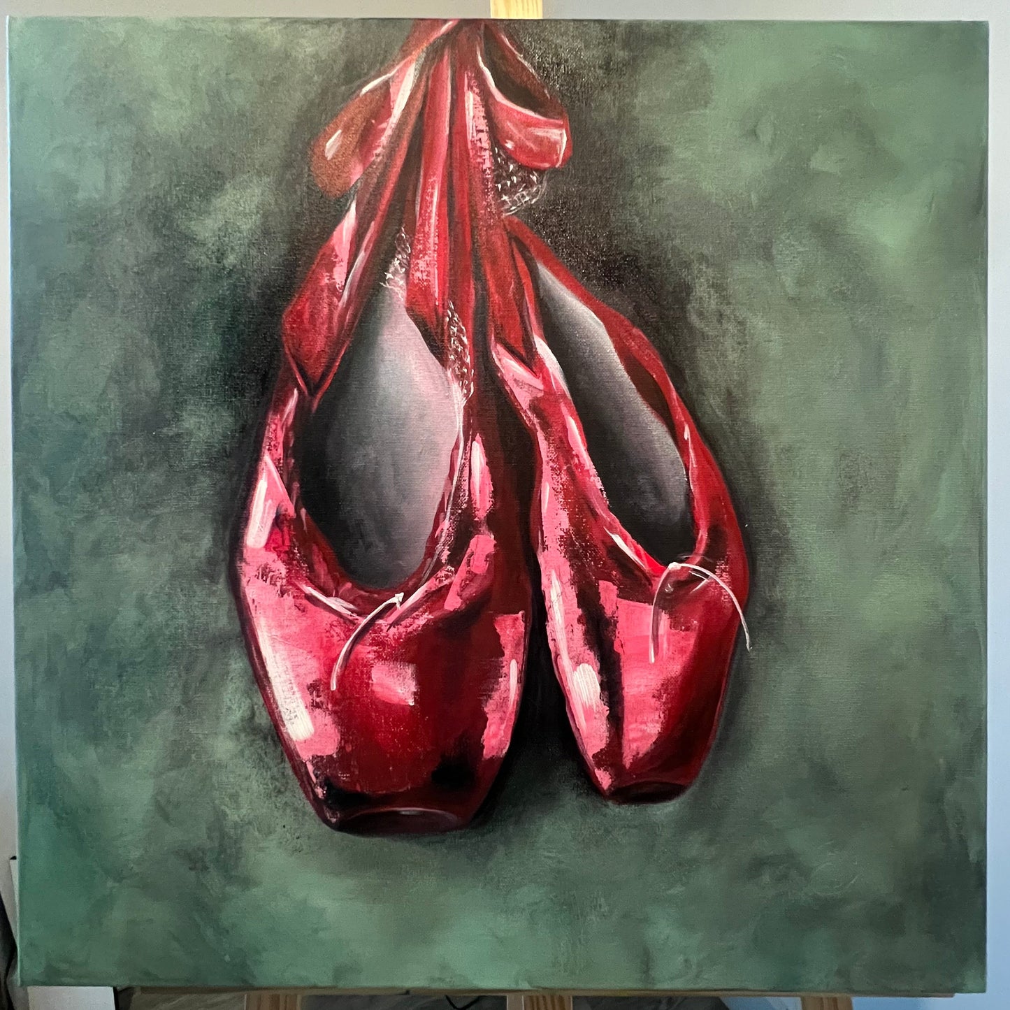 Red ballet shoes on a textured green background