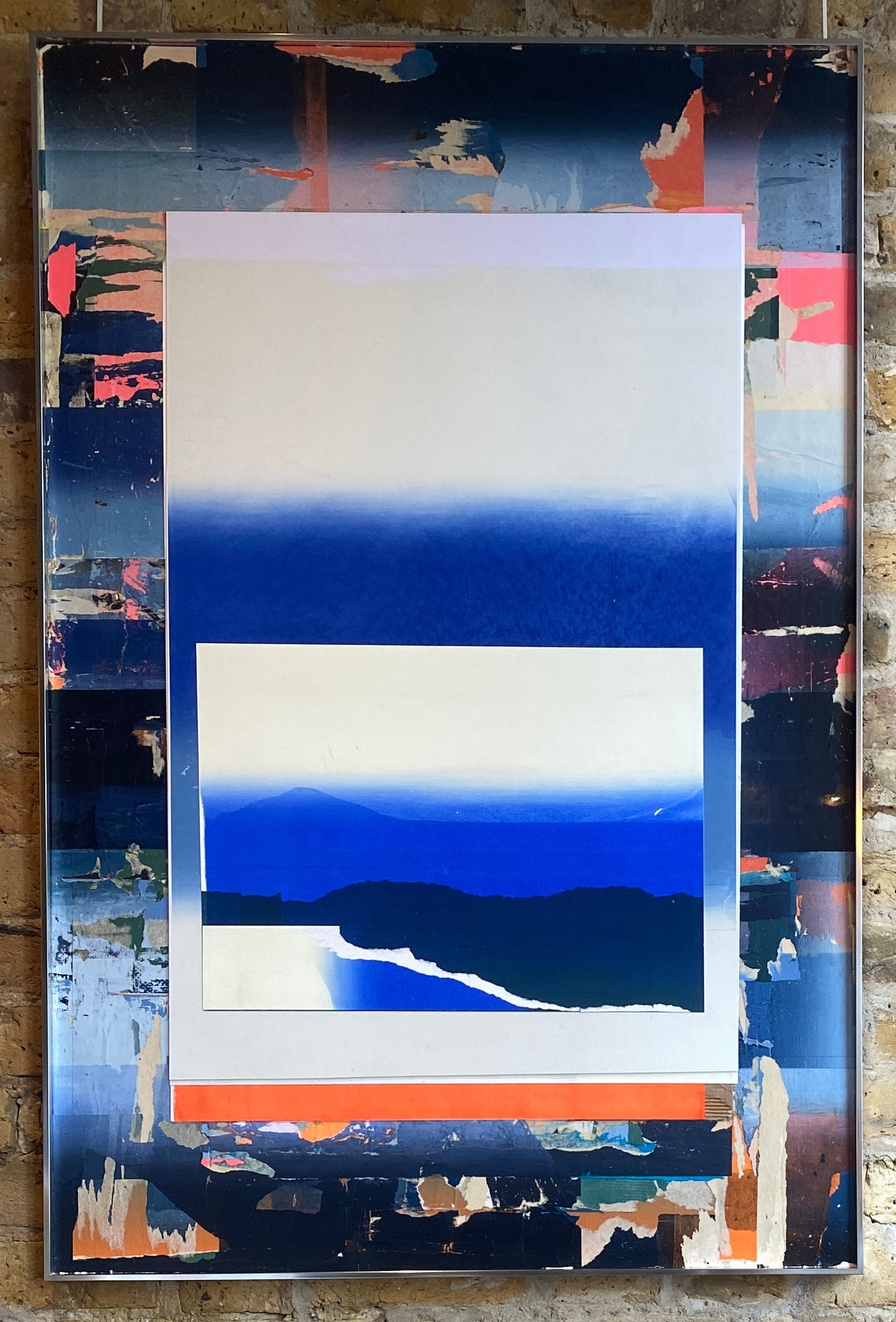 Abstract art piece with blue, white, and orange colors on a textured wall background