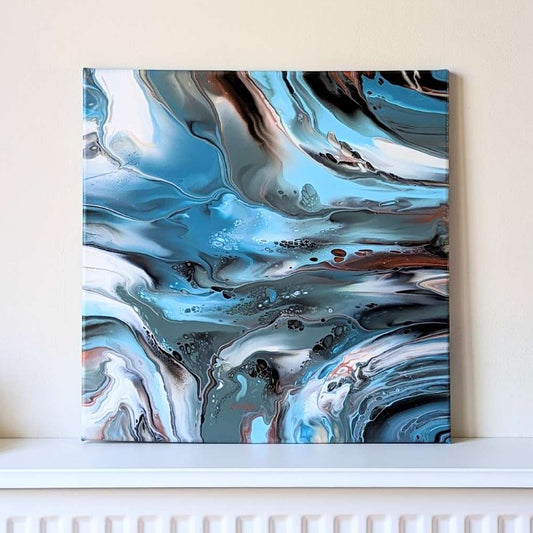 Abstract art piece on a wall above a radiator with candles and a plant.