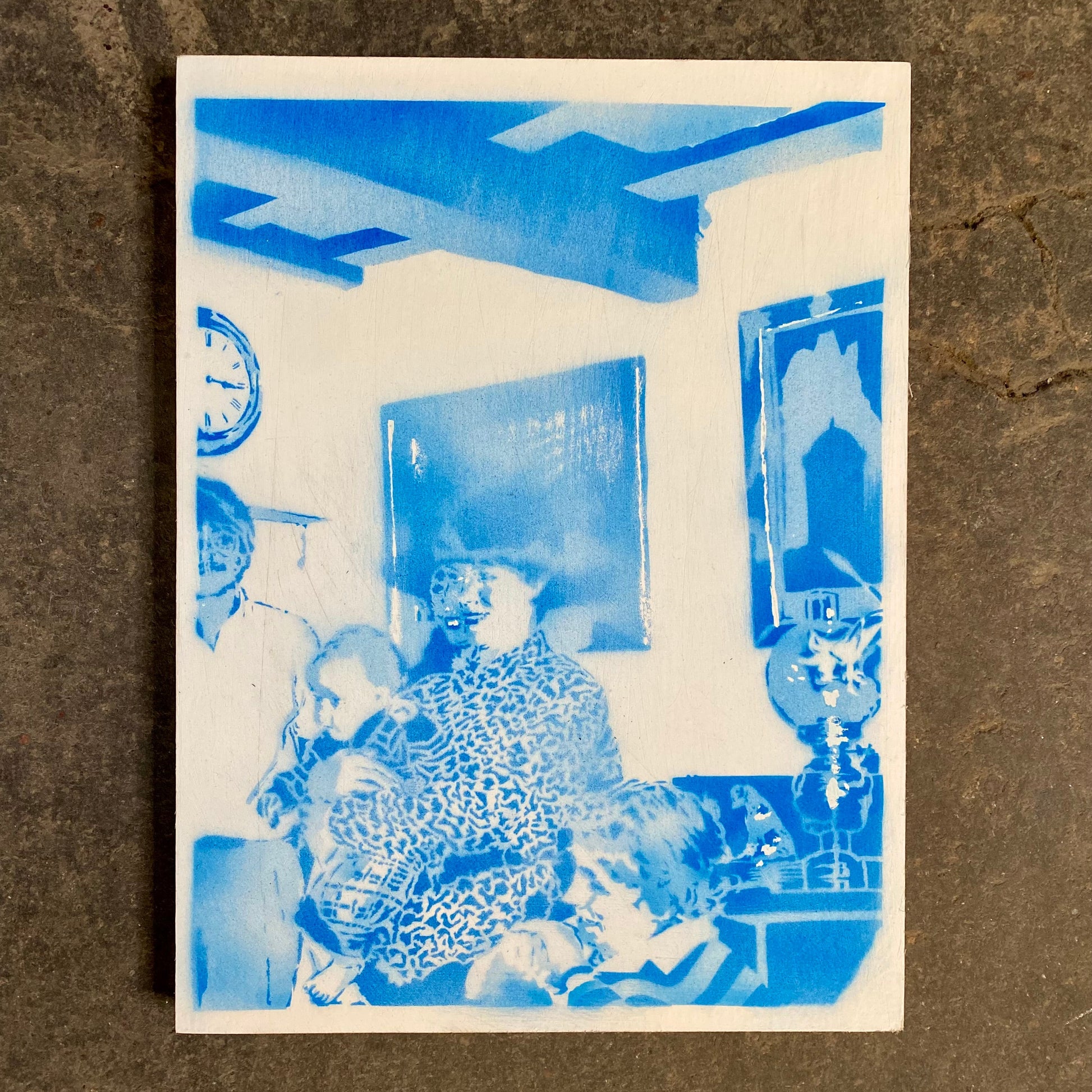 Blue-toned photograph of a family sitting together, with a brown textured background.