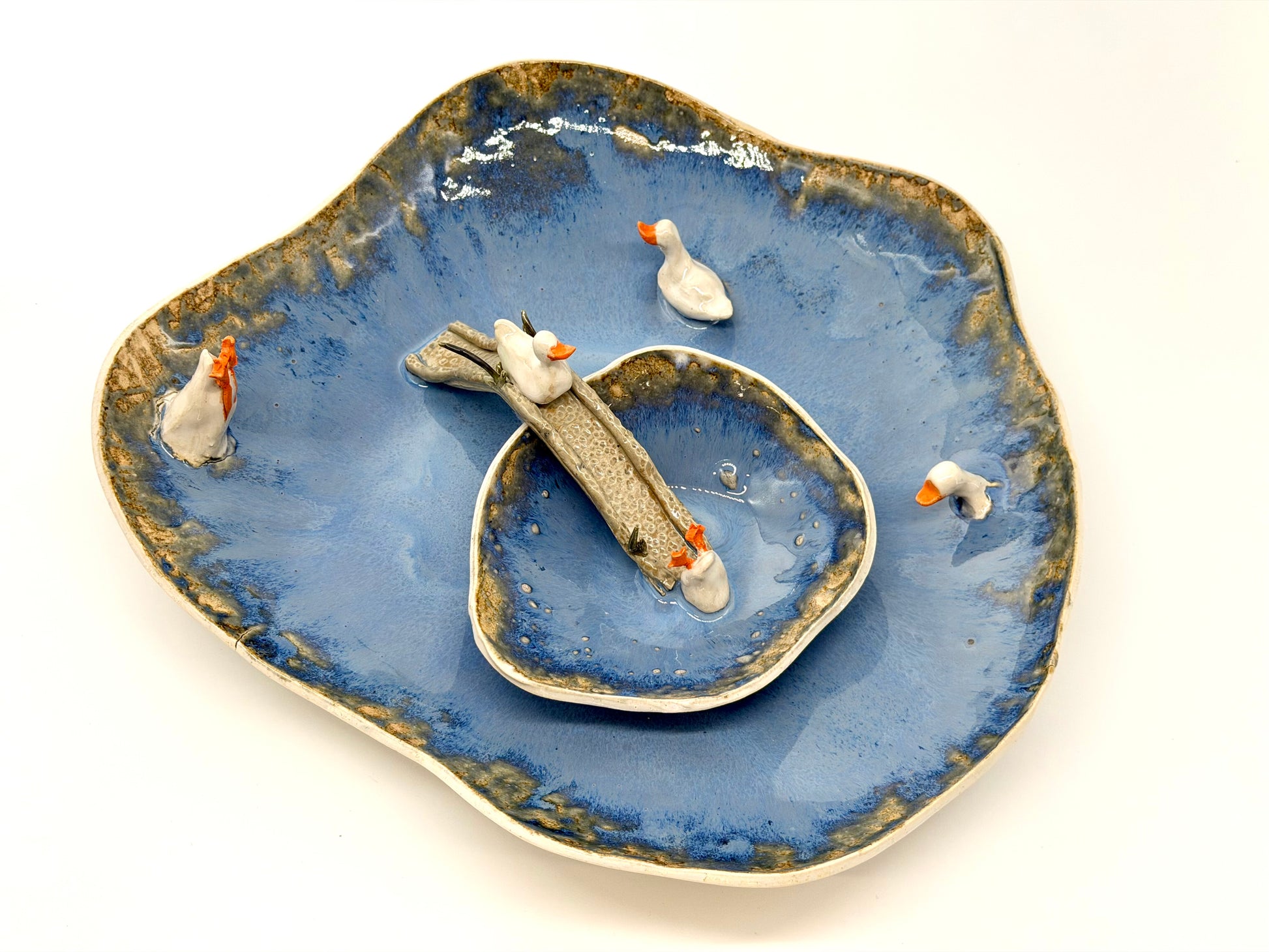 Ceramic plate with a blue glaze and decorative elements on a white background