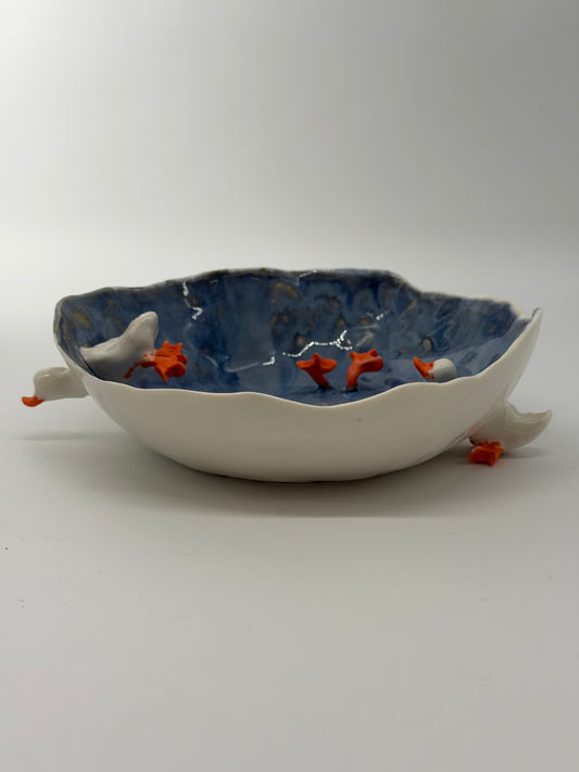 Ceramic wall art piece with fish design on a plain background