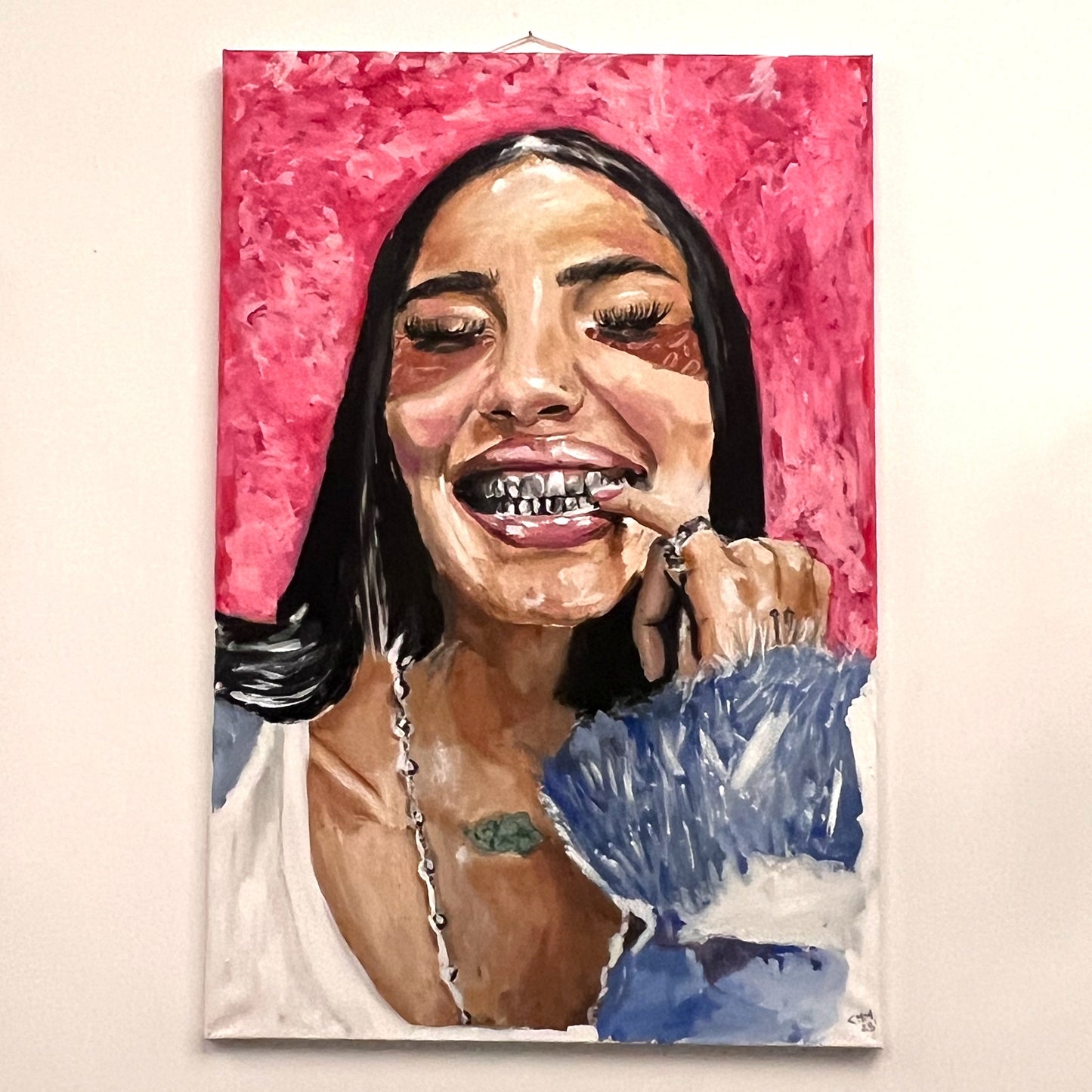 Portrait of Gio showing silver teeth grills and wearing a blue textured fur coat against a pink backdrop, available at HEADS Art Gallery.