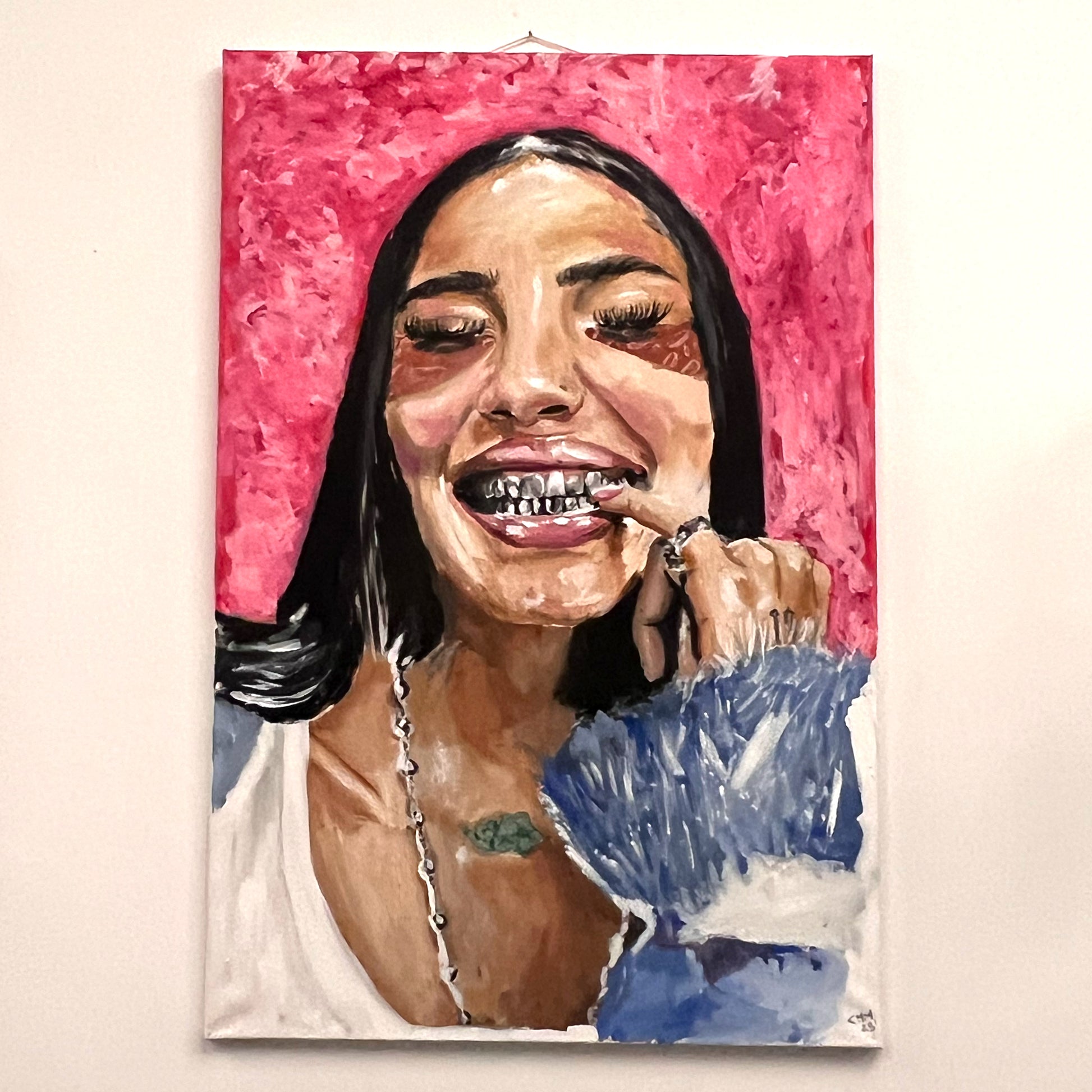 Portrait of Gio showing silver teeth grills and wearing a blue textured fur coat against a pink backdrop, available at HEADS Art Gallery.