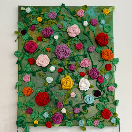 Mixed-media painting featuring hand-crocheted 3D roses and vines in various colors sprawling across a textured canvas, available at HEADS Art Gallery.