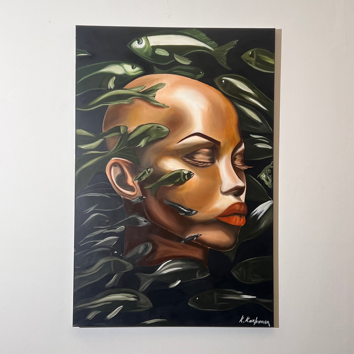 Surrealist portrait bald figure with closed eyes, with numerous small green and silver fish swimming across and around their face, available at HEADS Art Gallery.