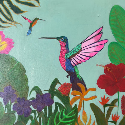 Bright and colorful painting of a vibrant hummingbird in mid-flight surrounded by lush tropical jungle foliage and red hibiscus flowers, available at HEADS Art Gallery.