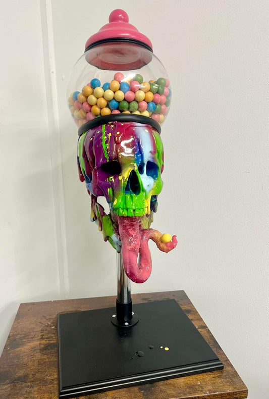 Colorful melting rainbow skull glass gumball machine filled with colourful candy sculpture on a wooden base available at HEADS Art Gallery.