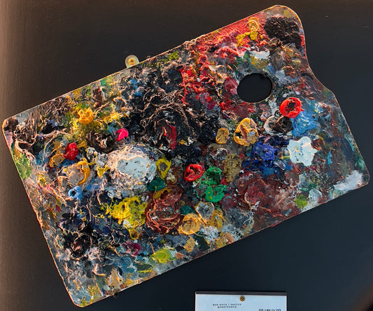 Real wooden artist's palette covered in thick, vibrant impasto oil paint textures creating a unique abstract display, available at HEADS Art Gallery.